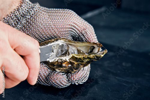 Canvas Print Opening oyster with knife