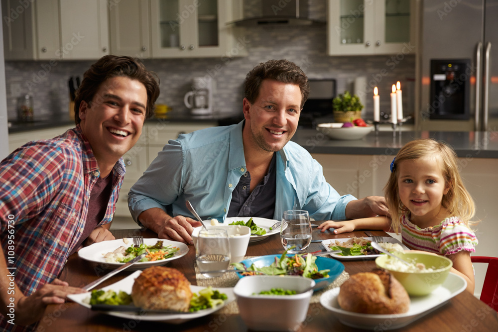 Male gay couple and daughter dining at home look to camera Male gay couple and daughter dining at home look to camera