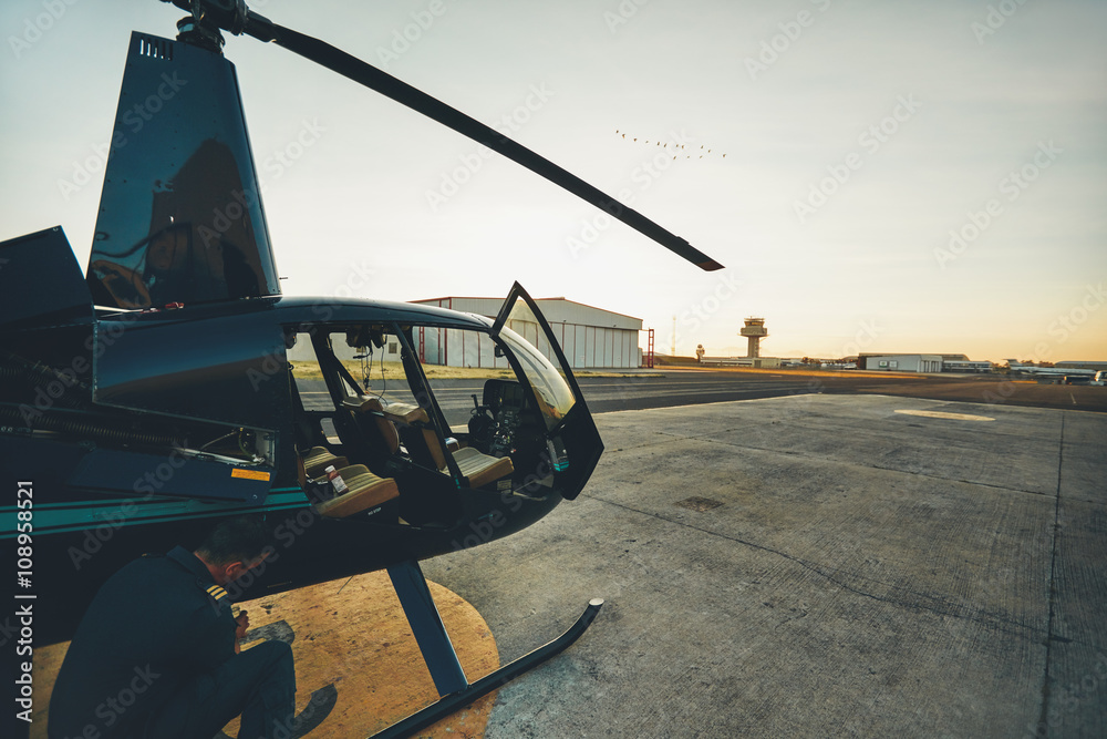 Fototapeta premium Pilot doing pre flight inspection at helicopter