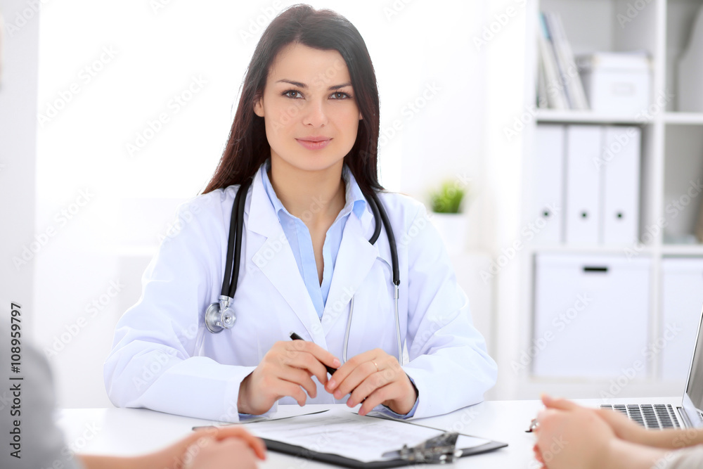 Brunette female doctor talking to patient in the hospital Brunette female doctor talking to patient in the hospital