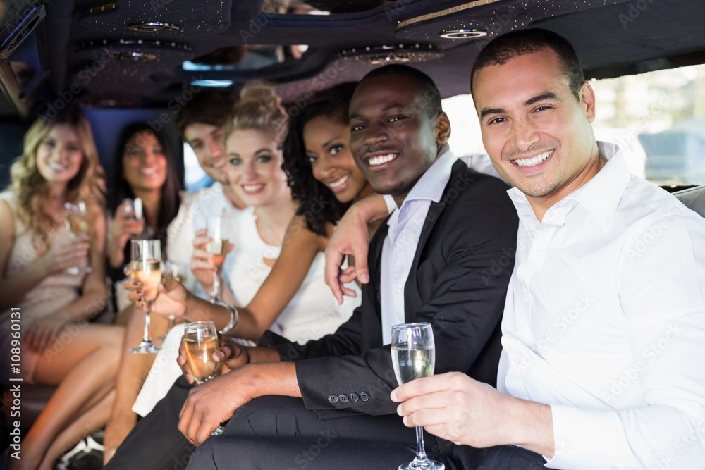 Well dressed people drinking champagne in a limousine - obrazy, fototapety, plakaty 