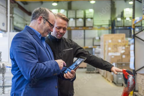 Manager and warehouseman discussing logistics in storage photo