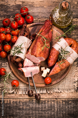 Antipasto catering platter with salami and meat on a wooden background photo