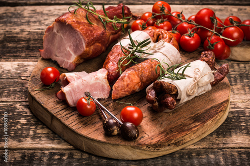 Antipasto catering platter with salami and meat on a wooden background photo