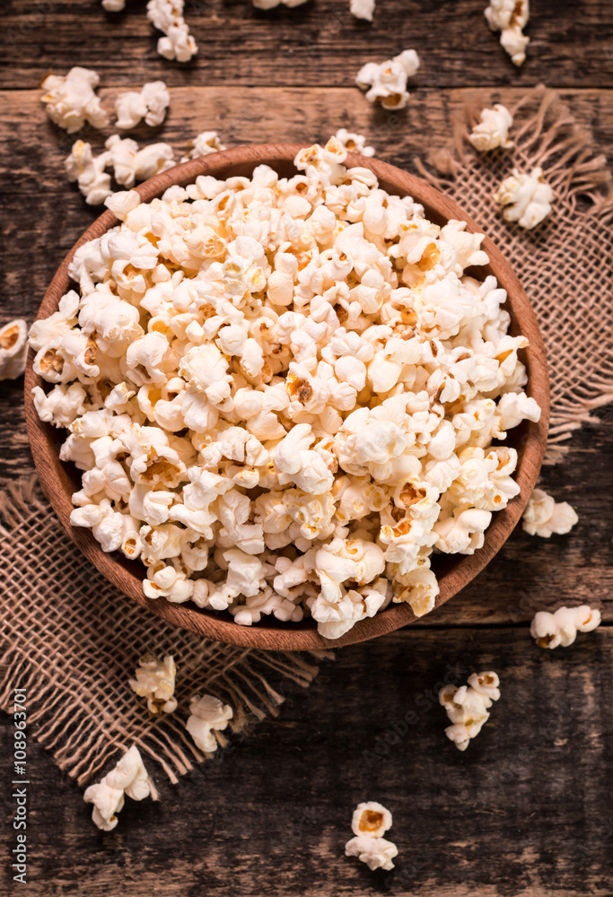 A bowl of popcorn on a wooden table A bowl of popcorn on a wooden table