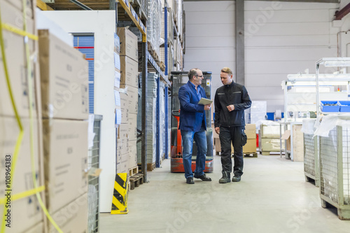 Manager and warehouseman discussing logistics in storage photo