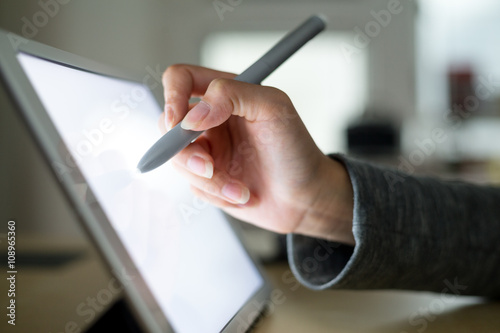 Woman drawing on tablet with pen