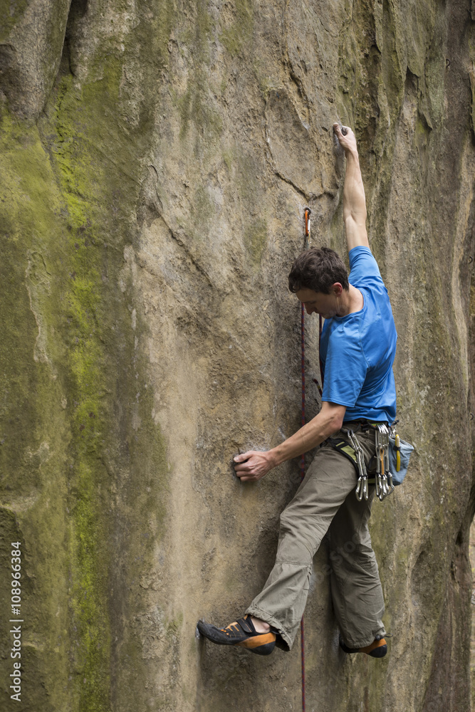 Fototapeta premium Athlete climbs on rock with rope.