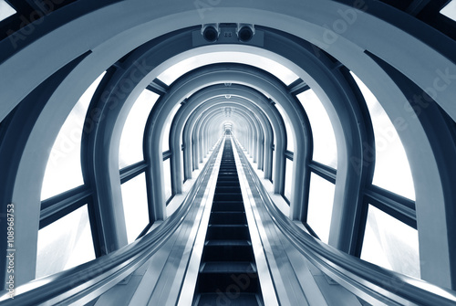Futuristic tunnel and escalator of steel and metal, interior view