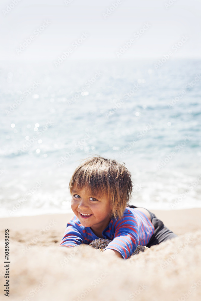 Portrait of little boy playing on the beach at seafront Portrait of little boy playing on the beach at seafront