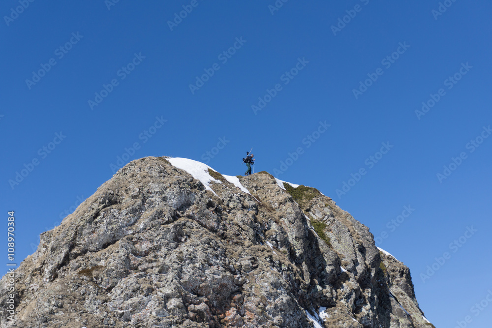 Man with snowboard on top of a mountain, extreme moutaineering.