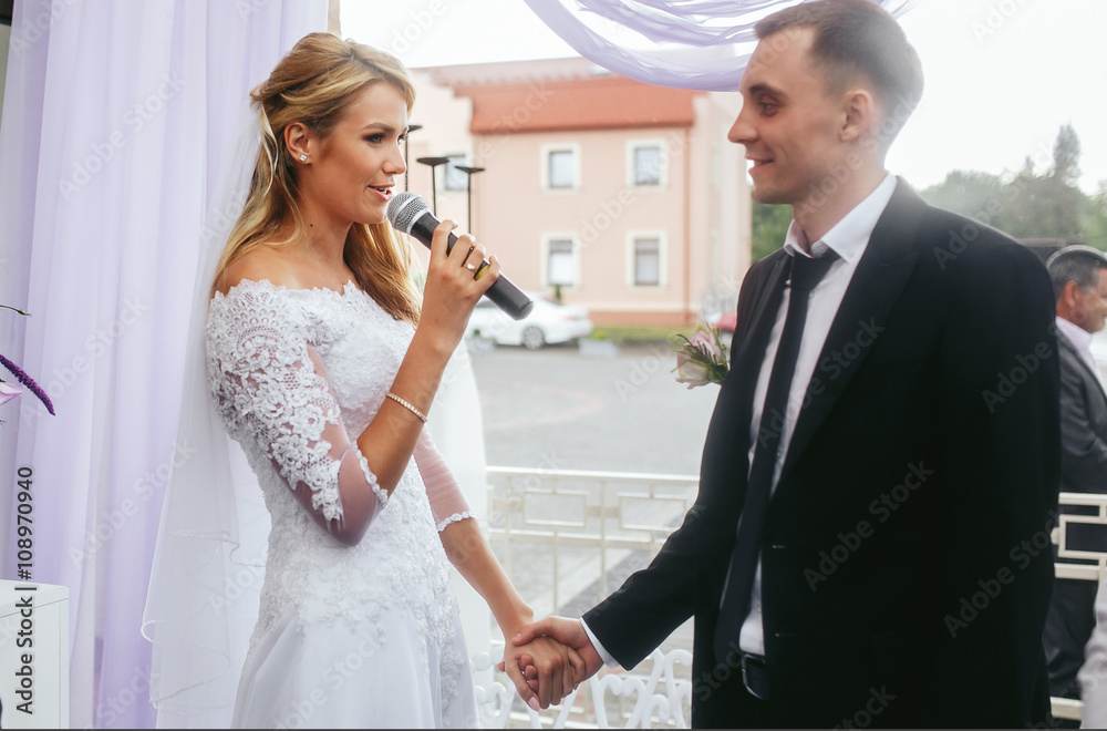 Beautiful blonde bride & groom taking vows at wedding ceremony Beautiful blonde bride & groom taking vows at wedding ceremony