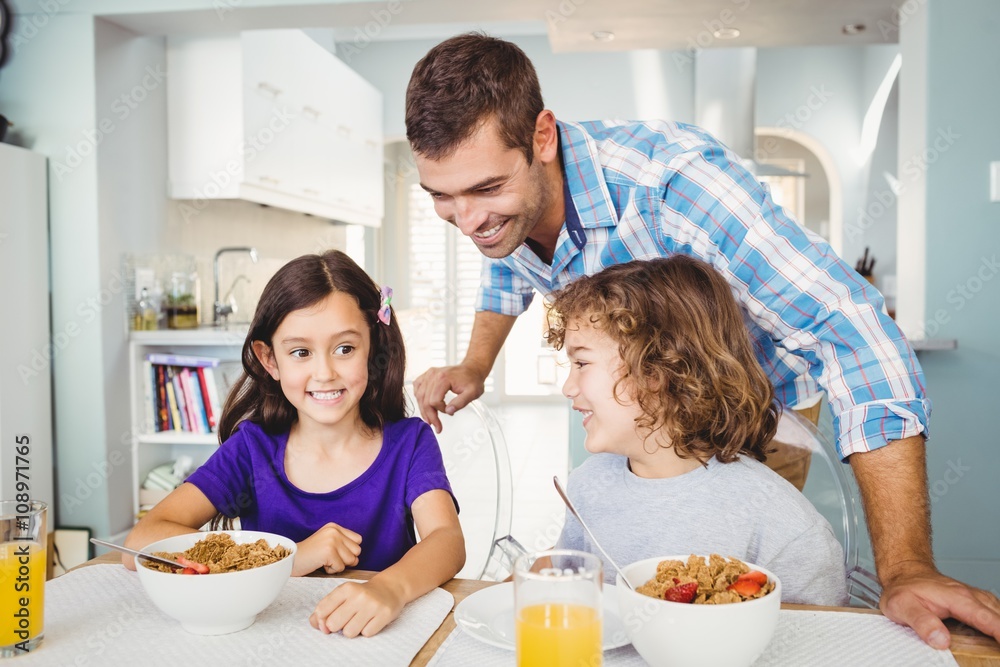 Happy man with children having breakfast