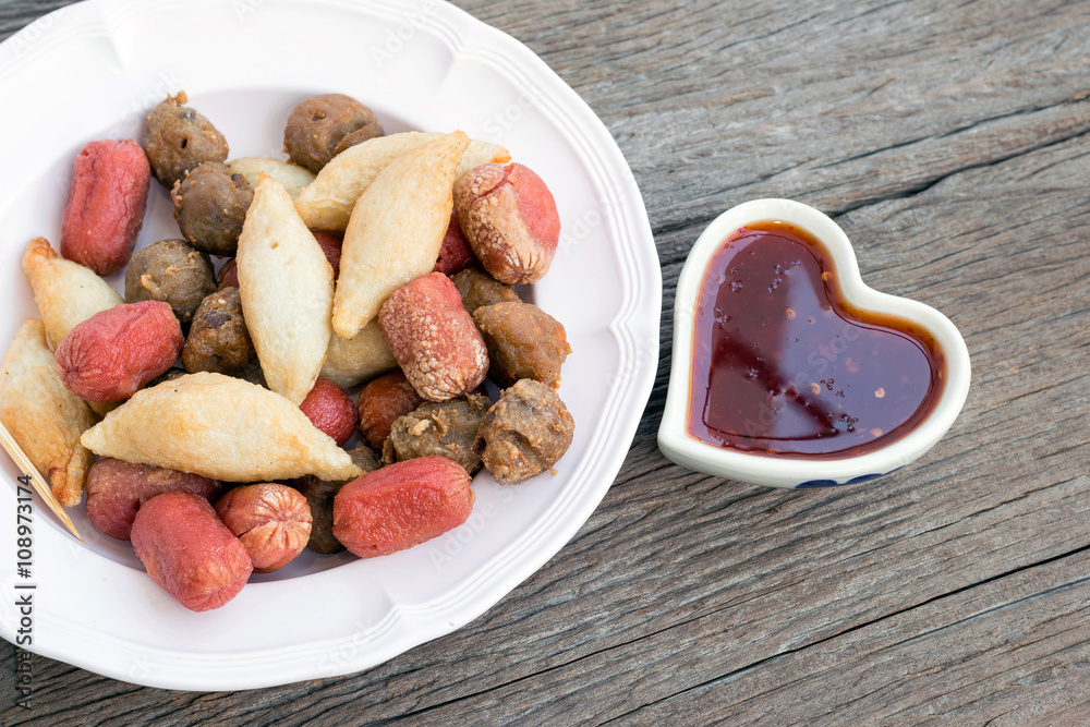 Fried meatballs with sauce in the Heart-shaped cup on wooden background. Fried meatballs with sauce in the Heart-shaped cup on wooden background.