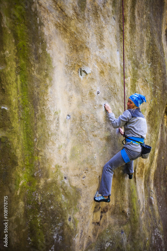 The girl climbs on the rock. © zhukovvvlad