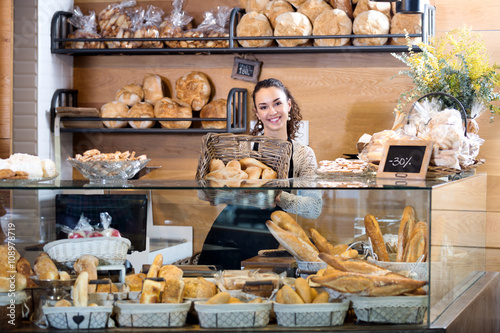 Female staff selling fresh pastry and baguettes