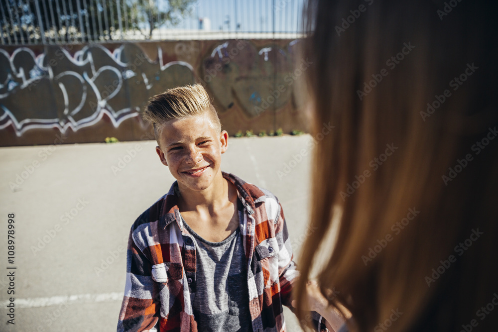 Portrait of smiling teenage boy face to face with his girlfriend Portrait of smiling teenage boy face to face with his girlfriend