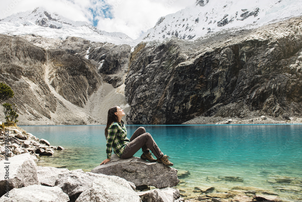 Peru, Huaraz, Huascaran National Park, woman relaxing after a trekking on lagoon, Laguna 69 Peru, Huaraz, Huascaran National Park, woman relaxing after a trekking on lagoon, Laguna 69