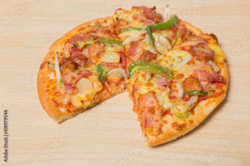 Pizza with sliced vegetables on wood