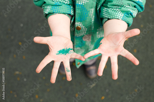 children's hands in wet paint. child touched something painted despite the sign Caution wet paint! do not touch. photo