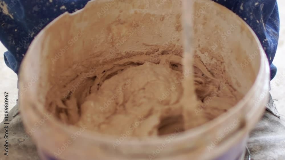 Renovation: man mixing colors to paint with a drill. Close up. Slow motion Renovation: man mixing colors to paint with a drill. Close up. Slow motion