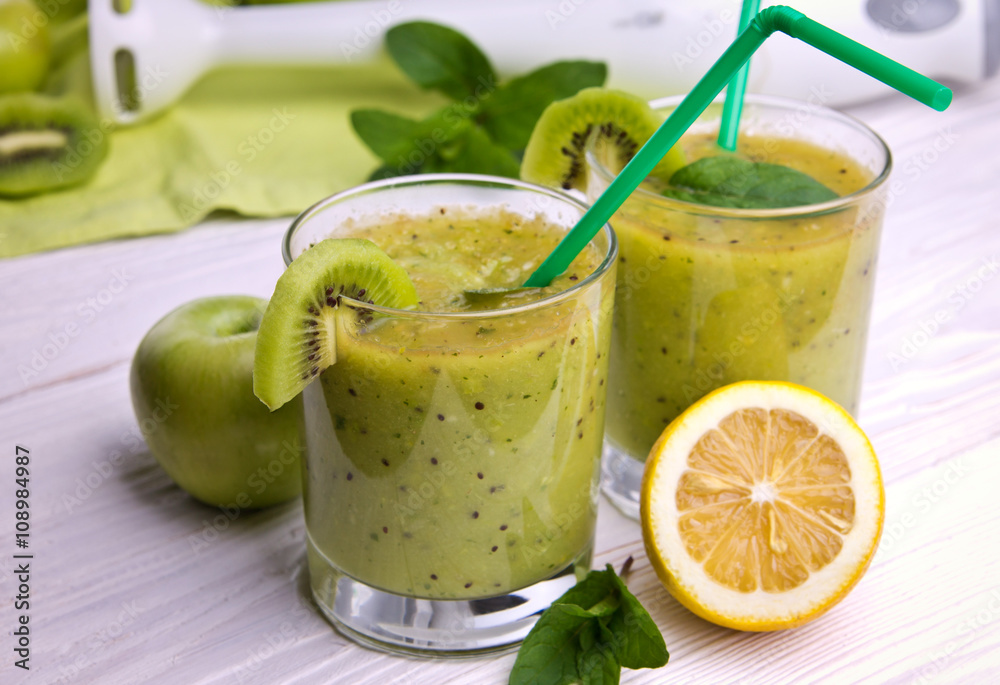 Green smoothie with mint and fruits on the wooden background Green smoothie with mint and fruits on the wooden background