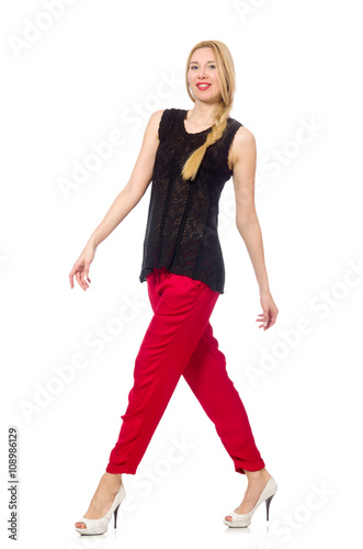 Tall young woman in red pants isolated on white