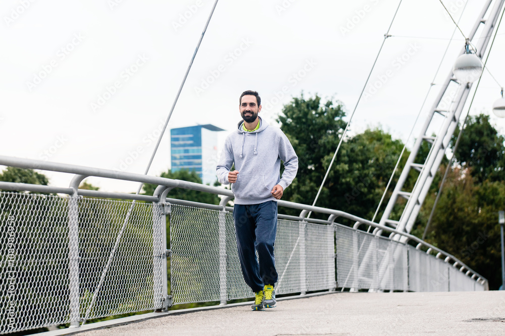 Man running as sport in the city over bridge