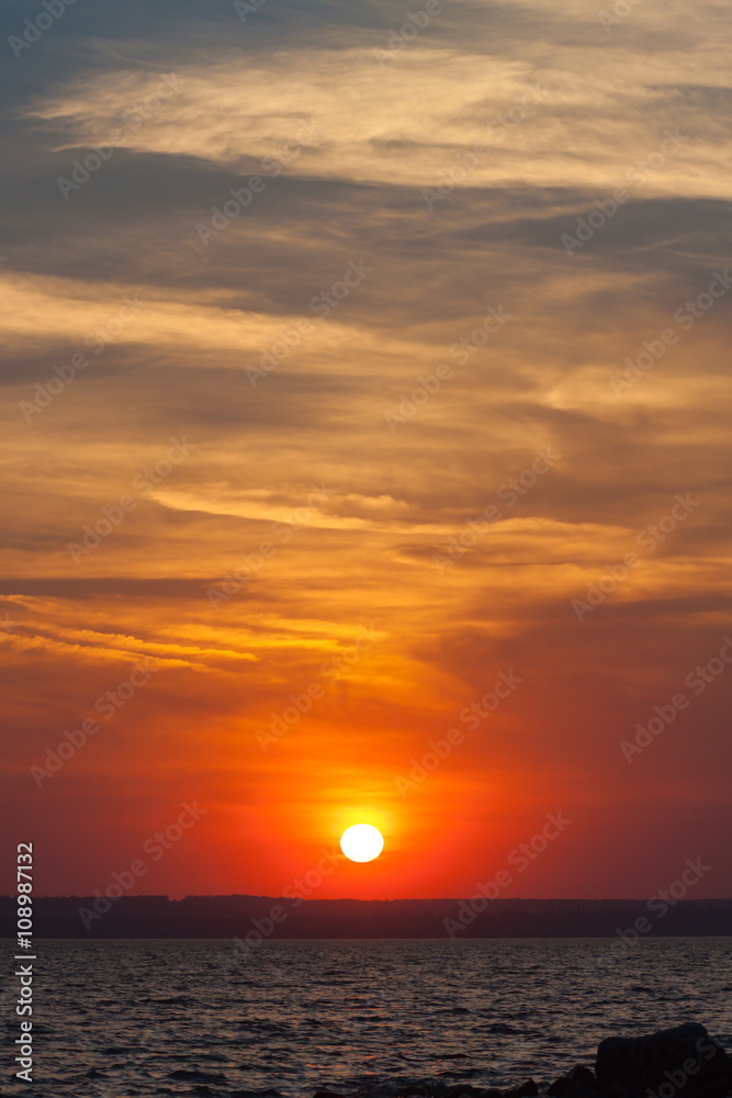 Dramatic sunset over the sea. the setting sun on a background of