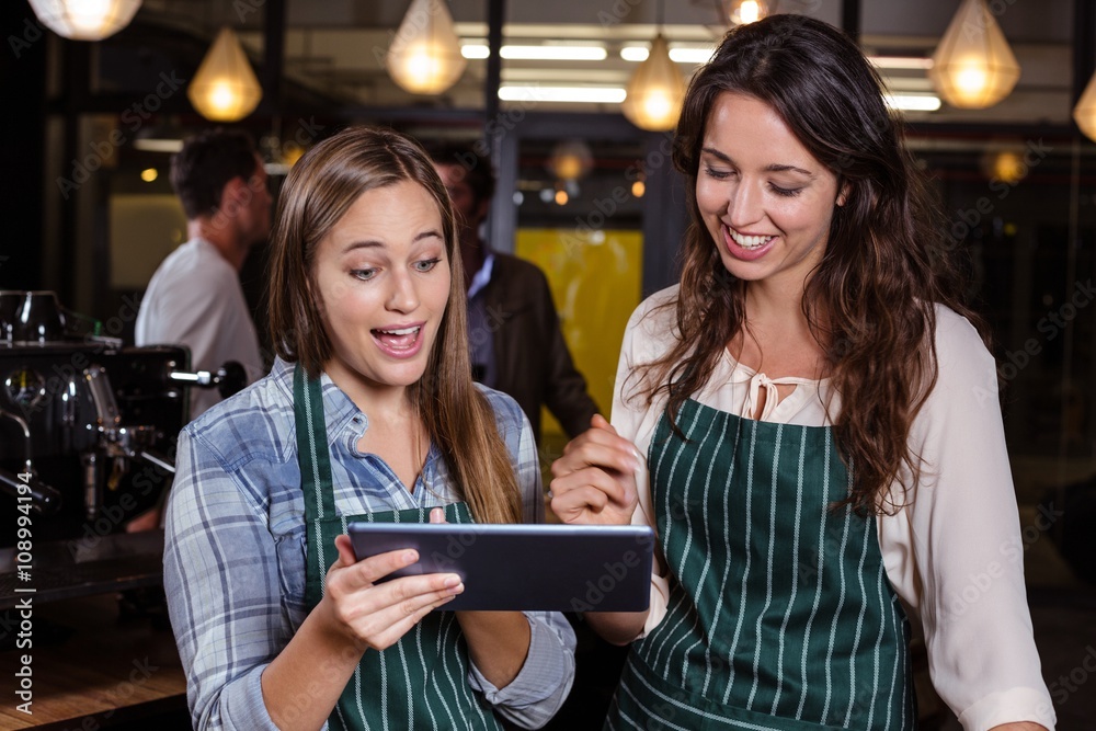 Pretty baristas using tablet