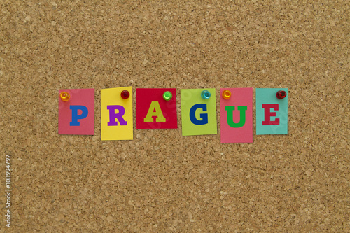Sticker Prague written on colorful notes pinned on cork board.