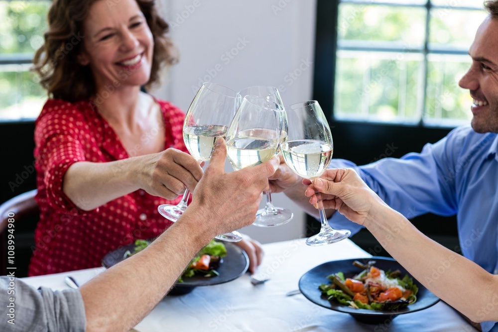 Happy friends toasting wine glass while having lunch Happy friends toasting wine glass while having lunch