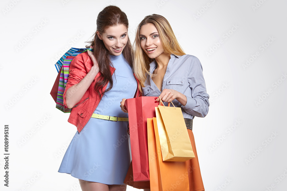 shopping, sale and gifts concept - two smiling teenage girls wit