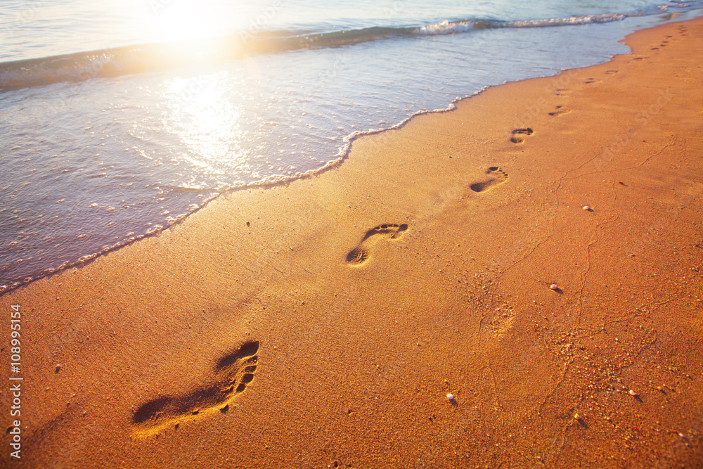 beach, wave and footprints at sunset time beach, wave and footprints at sunset time
