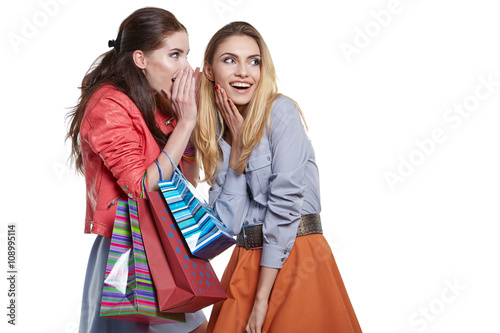 shopping, sale and gifts concept - two smiling teenage girls wit photo