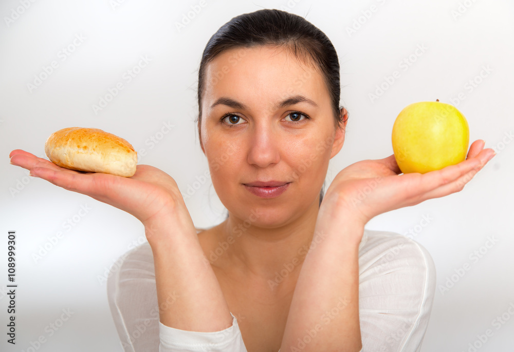 Dieting concept. Healthy Food. Beautiful Young Woman choosing between Fruits and Sweets. Dieting concept. Healthy Food. Beautiful Young Woman choosing between Fruits and Sweets.