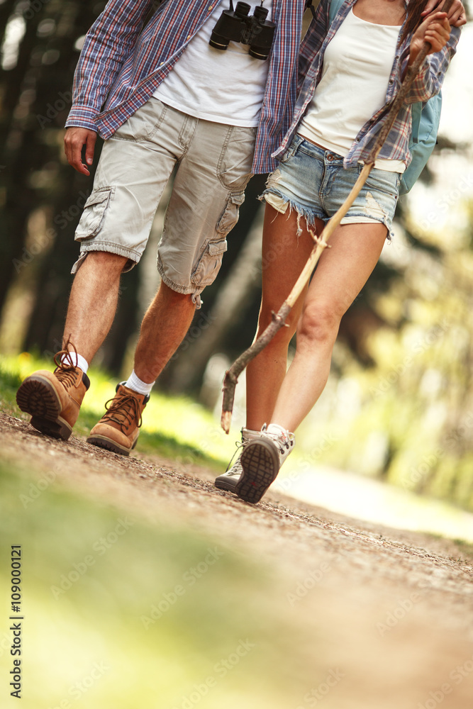 Obraz premium Young couple hiking in nature on beautiful summer day.Only legs are visible.