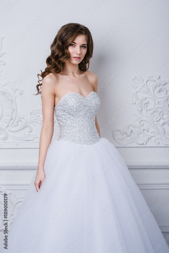 Young beautiful bride standing in antique interior ornamental design done with a moldings. Studio shot Young beautiful bride standing in antique interior ornamental design done with a moldings. Studio shot
