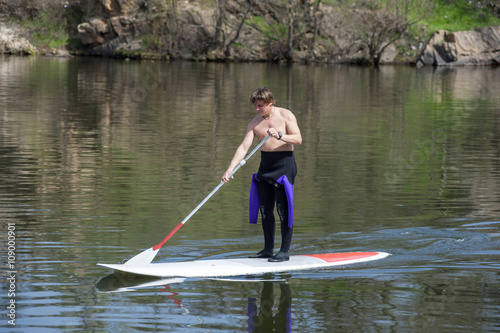 athletic man stand up paddle board SUP