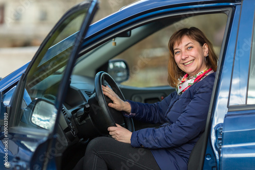Happy young woman driving her new car. © De Visu