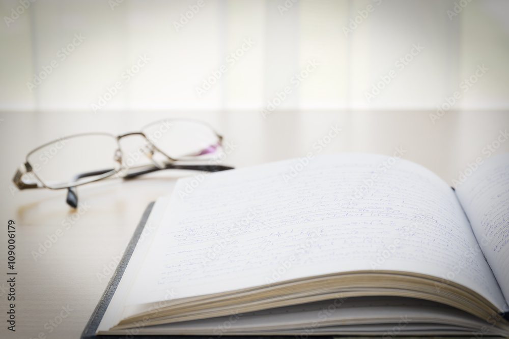 Book and eyeglasses with on the desk Book and eyeglasses with on the desk
