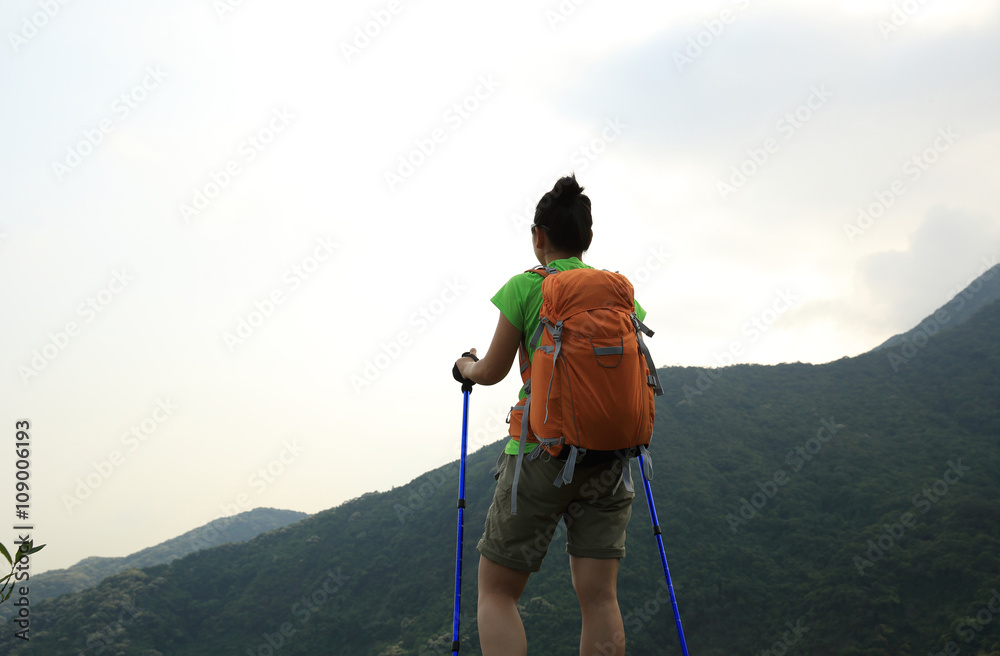 young woman backpacker at spring forest mountain peak