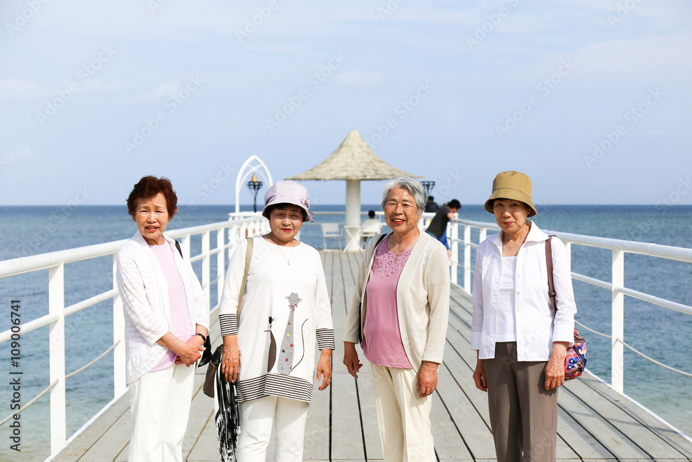 桟橋から景色を眺める高齢者女性