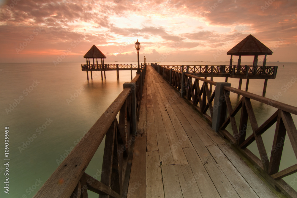 Long pier overlooking the sea during sunrise
