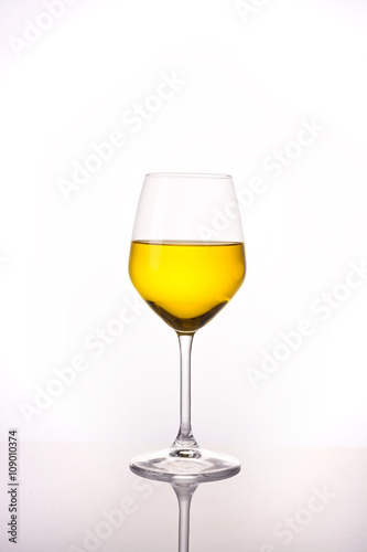 yellow water in wine glass on white background