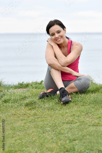 Fitness woman doing relaxation exercises by the sea © goodluz