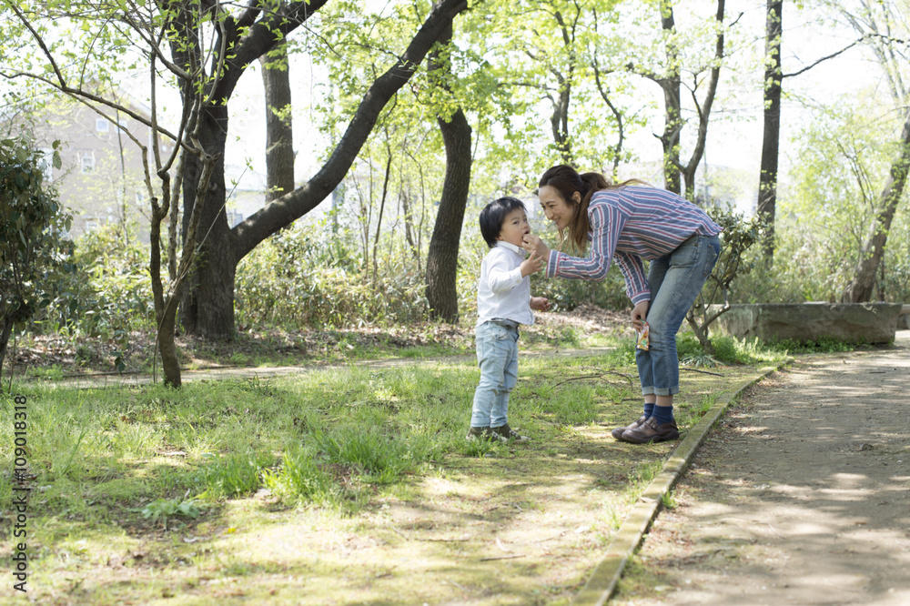 Young boy is trying to eat something in the park Young boy is trying to eat something in the park