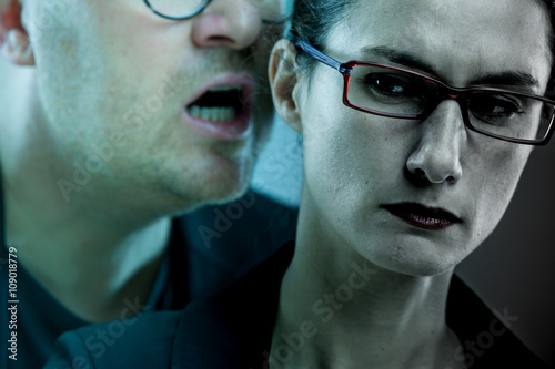 Fotografie man threatens woman: harassments on the workplace