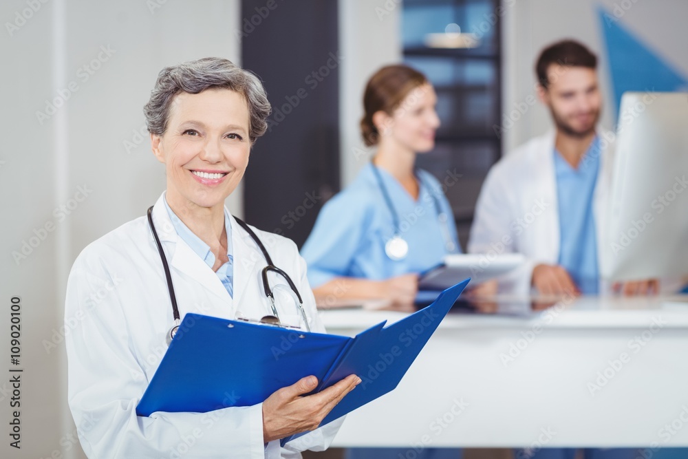 Portrait of happy female doctor holding medical reports Portrait of happy female doctor holding medical reports