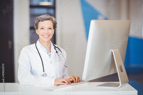 Portrait of smiling doctor working at computer desk